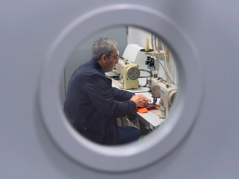 Het Nieuwe Logisch cutting and preparing waste materials for bag production | Waste Alchemists